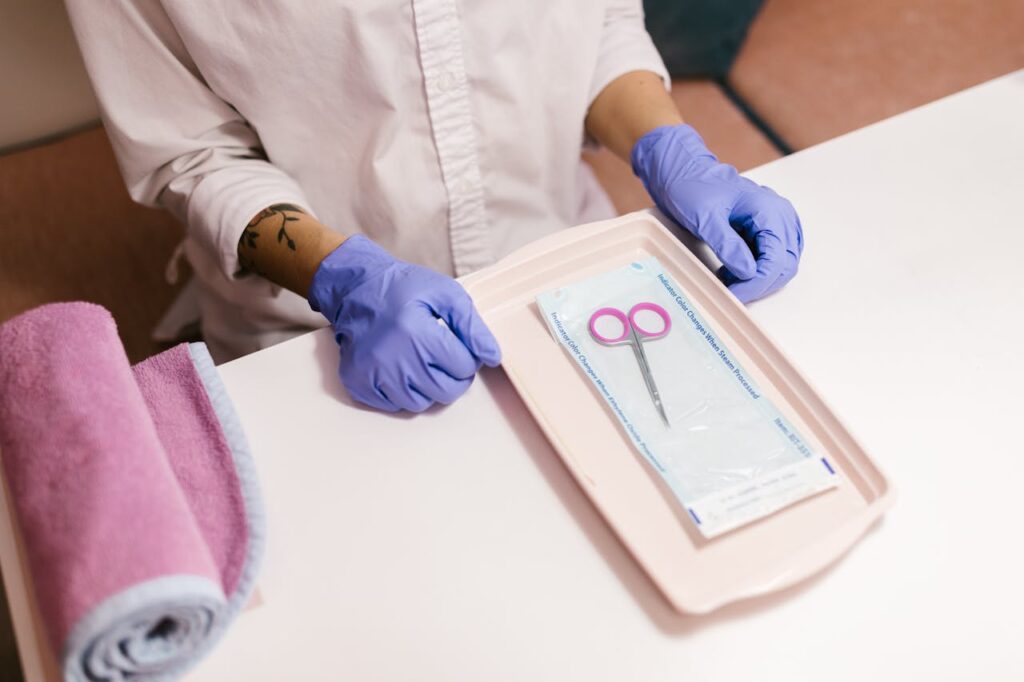 Nail technician with gloves preparing tools for a manicure session. Focus on hygiene and professionalism.