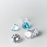 Close-up view of assorted sparkling gems on a white surface, showcasing brilliance.